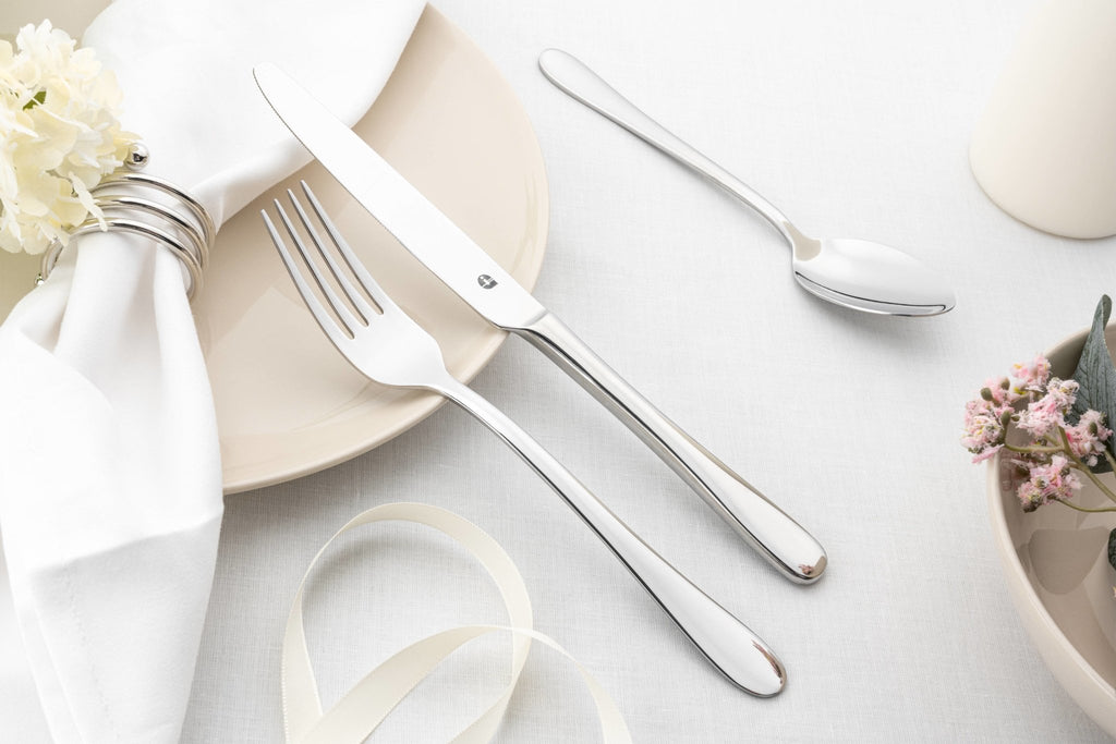 24 Piece Cutlery Set for 6 People Windsor 24BXWSR-IGLC Grunwerg Elegant stainless steel cutlery set on a white table cloth